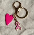 Pink October bag charm keychain in gold-plated stainless steel with a bright pink heart and light pink ribbon. Fight against breast cancer